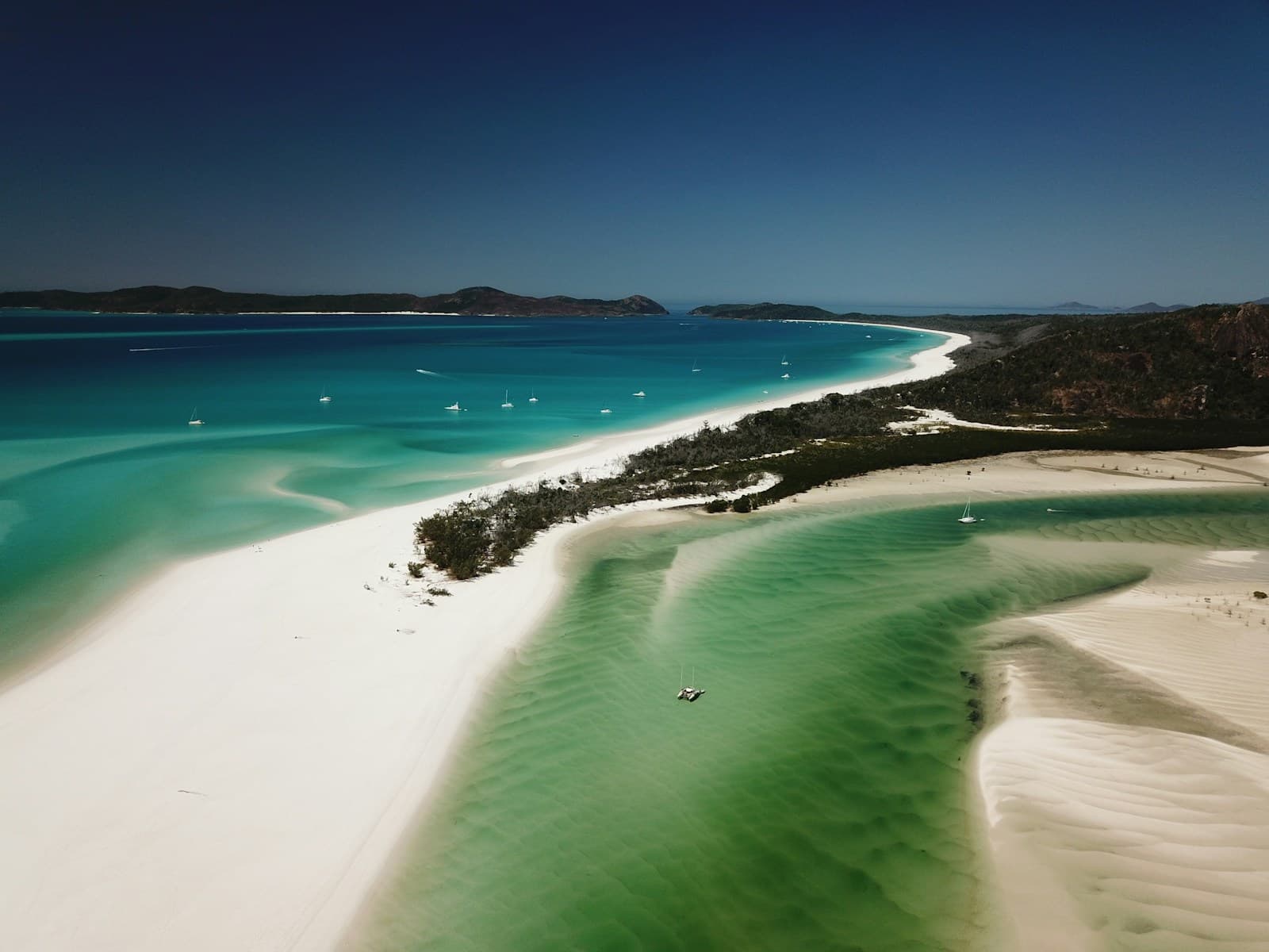 Elevated shot from the Hill Inlet lookout looking down over the swirling white sand and turquoise tidal channels of Whitehaven Beach, mid-morning light, no boats or people visible in the foreground. Avoid the stock tourism-board drone shot.